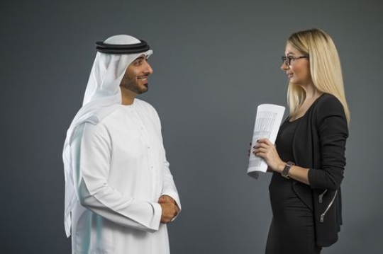 Side view of both business people standing talking to each other|