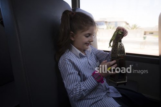 Middle Eastern student sitting in school bus with a Lantern |-