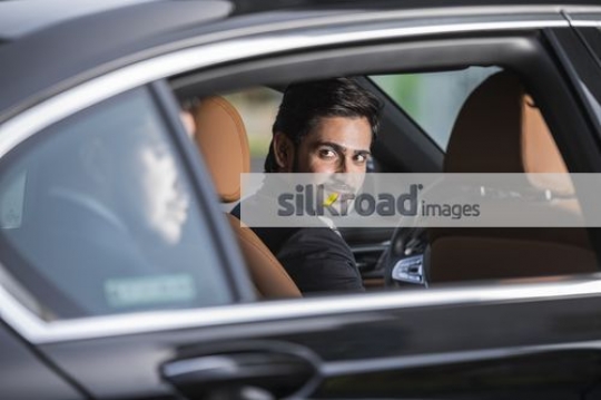 Expat Businessman looking at the passenger at the back|