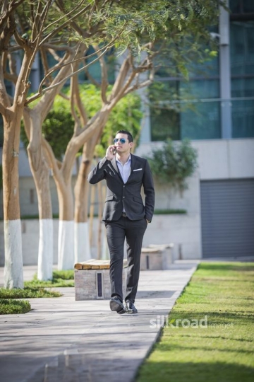 Arab Businessman walking and talking on the phone|-