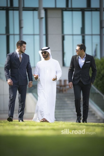 Middle Eastern Businessmen talking to his colleagues walking next to him|-