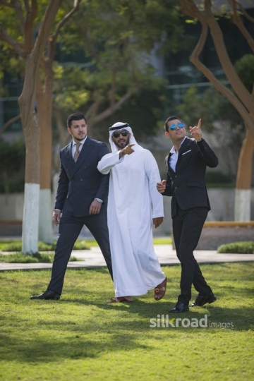 Arab Businessman pointing and the Western Businessman is walking next to them|-