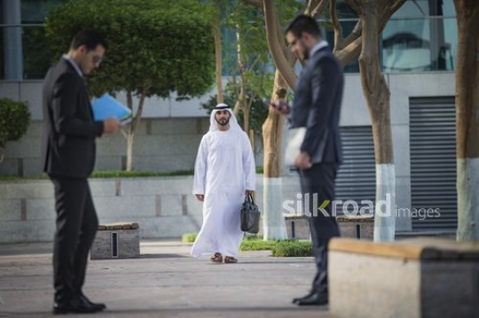 Middle Eastern Businessman walking towards his colleagues|-