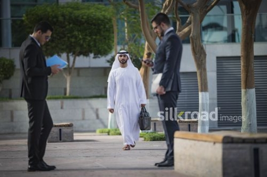 Businessman walking towards his colleagues|-
