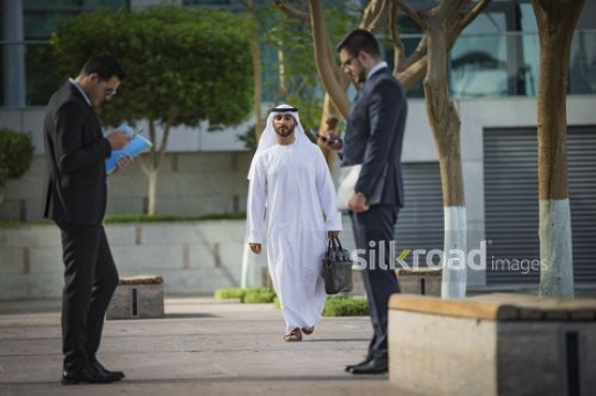 Arab businessman walking towards his colleagues|-