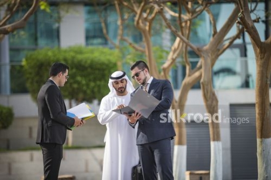 Western Businessman talking to his Middle Eastern colleagues |-