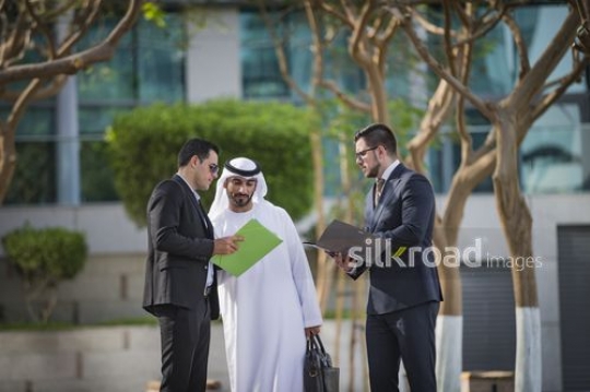 Arab Businessman talking to his colleagues outside|-