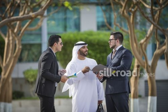Group of Businessmen standing together outside talking to each other|-