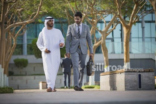 Two Businessmen walking together outside|-