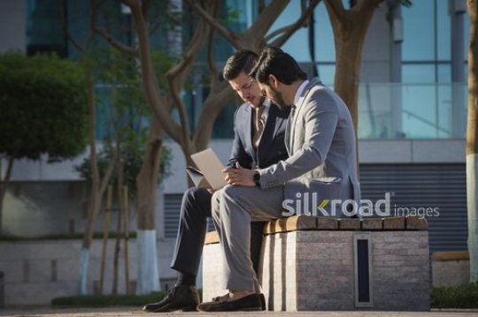 Businessmen sitting together working|-