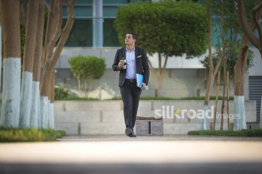 Middle Eastern businessman walking|-