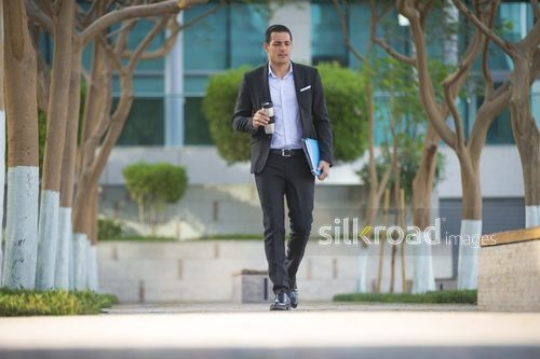 Middle Eastern businessman walking|-