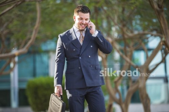 Western Business man walking and having a phone call|-