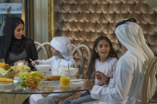 Middle eastern family sitting all together during breakfast|-