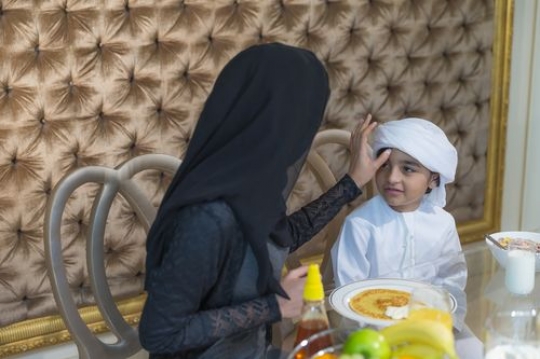 Arab mother and boy sitting together|-