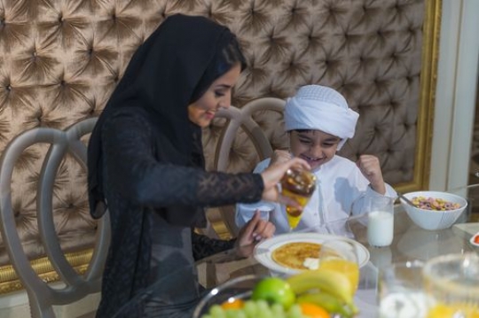 Arab mother and son sitting together during breakfast |-