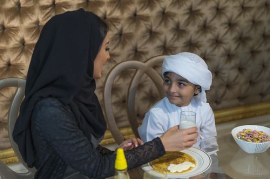 Arab mother talking to her son during breakfast|-