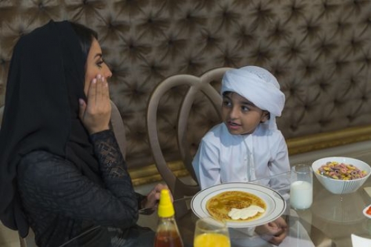 Arab mother and son sitting together|-