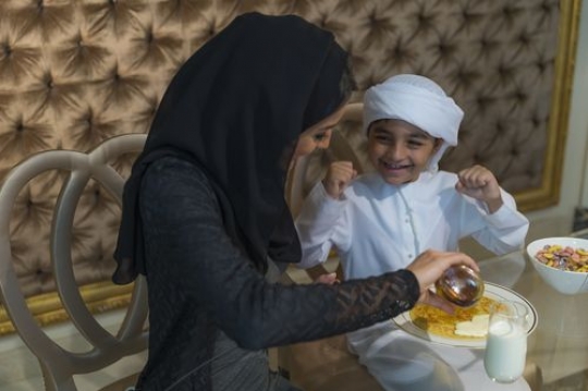 Arab mother preparing food for her son|-