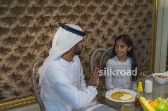 Young Middle Eastern woman sitting together during breakfast|