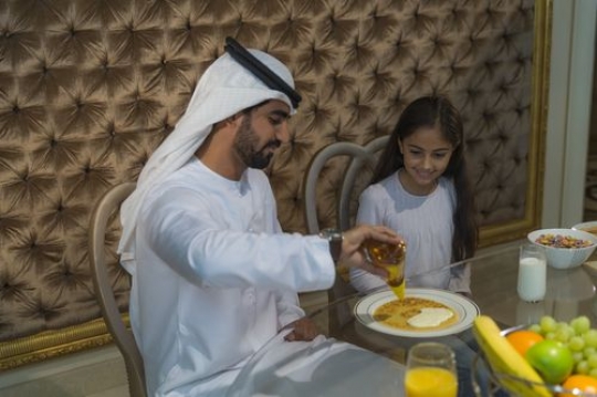 Arab father preparing food for his daughter |-