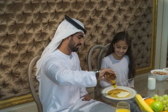 Arab father putting food for his daughter|-