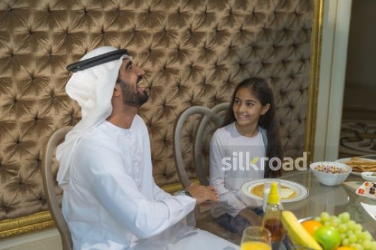 Middle Eastern father and daughter sitting together |