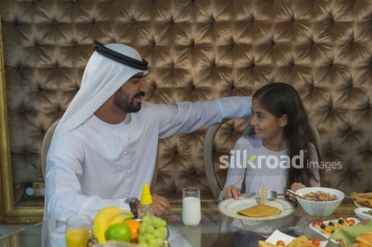Arabian man and young girl bonding during breakfast|