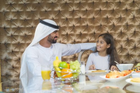 Arab man sitting with the young girl during breakfast |-