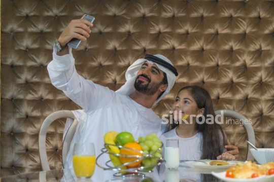 Arab man and little girl taking a selfie together|