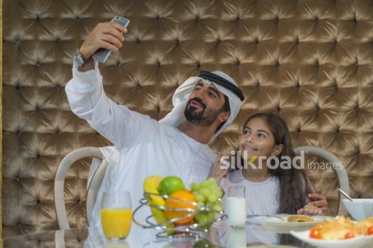 Middle Eastern man taking a photo with the young arab girl|