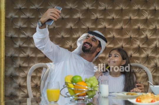 Arab man taking a photo with the young girl|