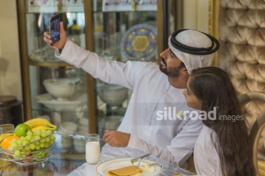 Middle man and young girl taking a photo together|