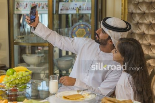 Arab man and young girl taking a photo together|