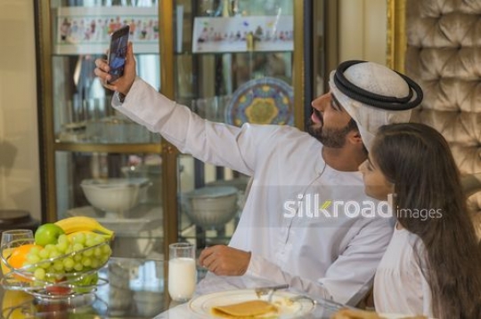 Middle Eastern man and young girl taking a picture together|