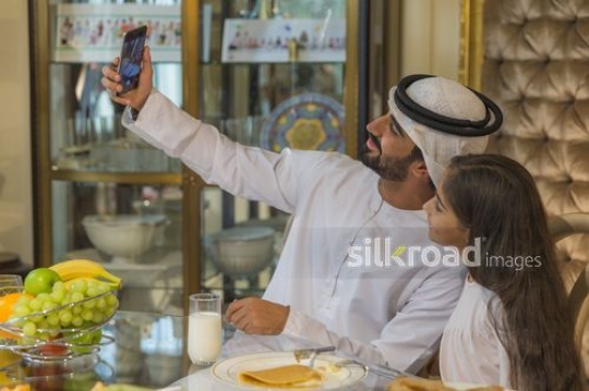 Arab man and young girl taking a selfie together|