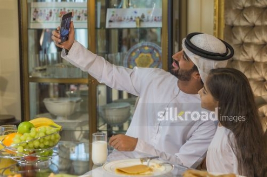 Middle Eastern man taking a selfie with the young girl|