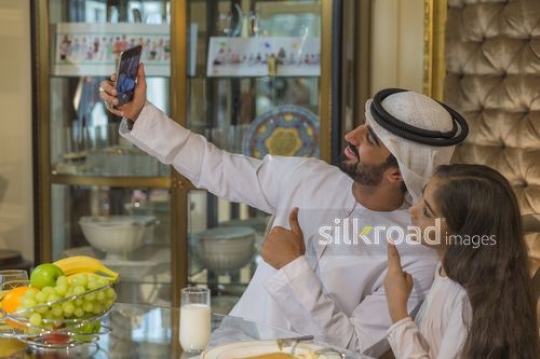 Arabian father and daughter taking a selfie together|