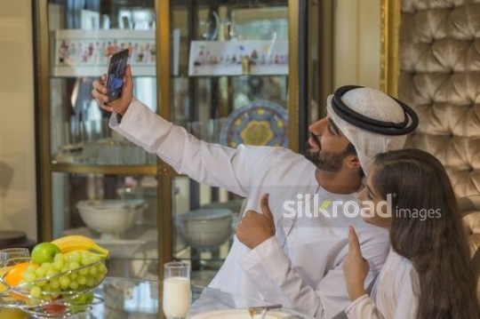 Arabian man taking a photo with the young girl|