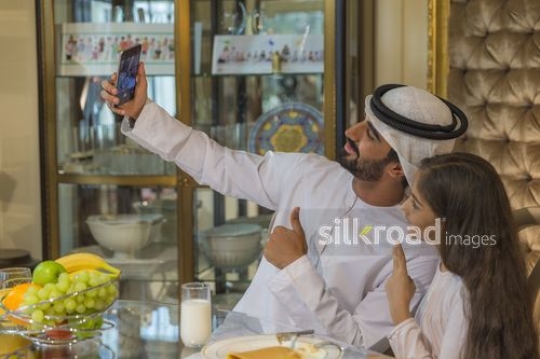 Family taking a photo together during breakfast|