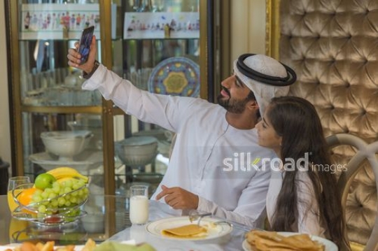 Arab man taking a picture with the young girl|