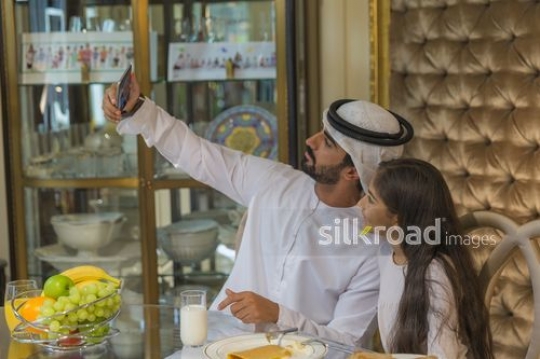 Middle Eastern man taking a selfie with the young girl |