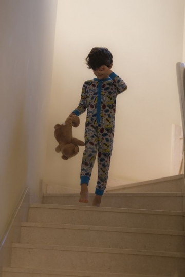Young middle eastern boy walking down the stairs|-