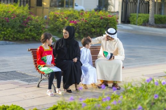Family sitting on the bench celebrating national day|-