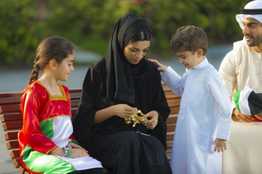 Family dressed in traditional attire celebrating national day|-