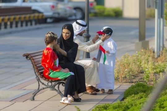 Mother and father helping their kids with their outfits to celebrate national day|-