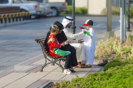 Arab family dressed in traditional attire celebrating national day|-