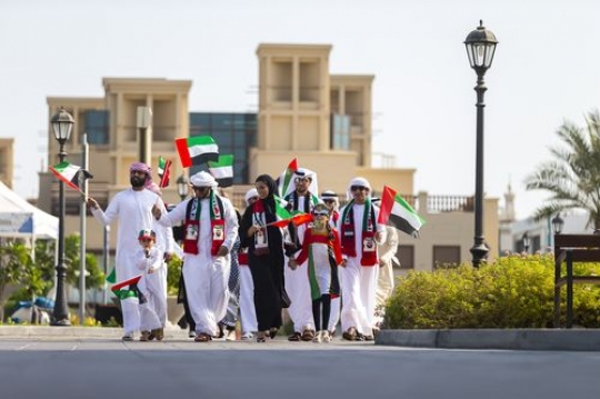 A group of family and friends at a parade celebrating National day|