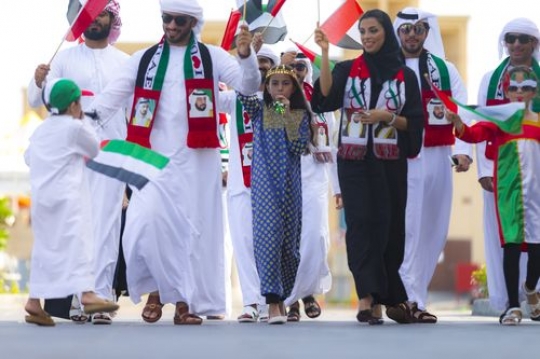 A group of family and friends representing their country during a National Day parade|