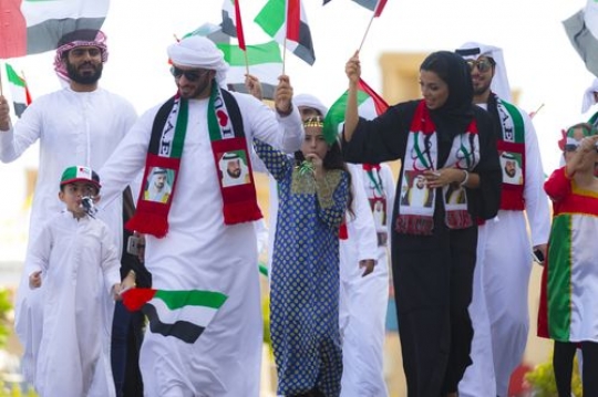Middle eastern family and friends representing their country during the UAE National Day parade|
